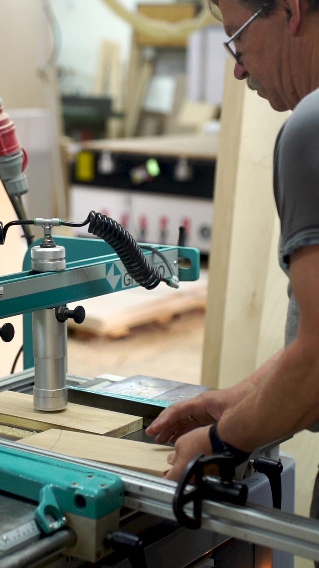 Meubelmaker bewerkt hout in de werkplaats van Pastform voor de productie van handgemaakte platenkasten en vinylmeubels.